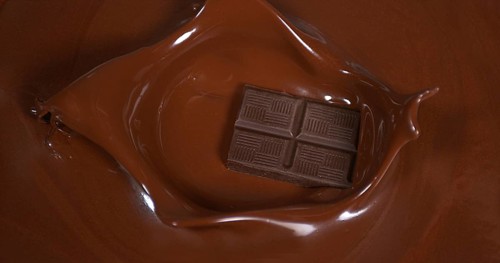 Black Chocolate tablet falling into Milk Chocolate