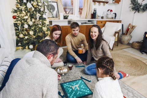 Big family sitting on floor playing intellectual board games together while spending leisure time