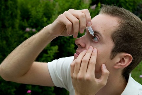 Young man takes eye drops, allergy, pollen allergy