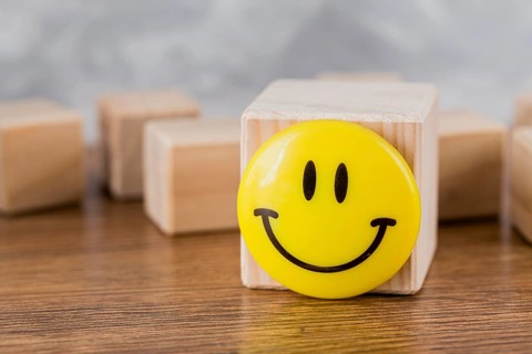 Front view smiley face wooden block. High resolution photo