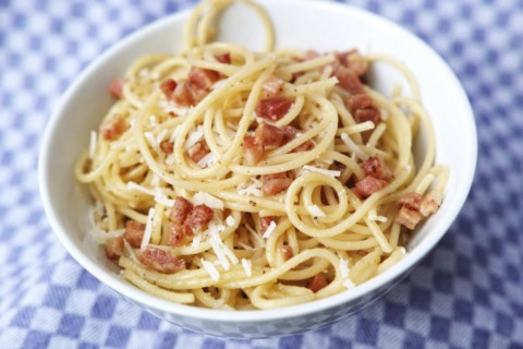 Spaghetti carbonara with bacon and parmesan in a porcelain bowl