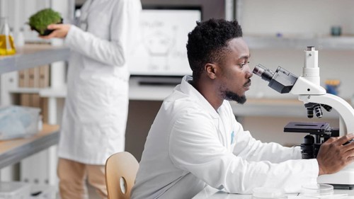 Side view male researcher laboratory with microscope
