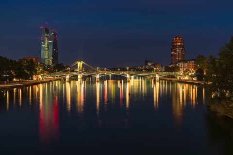 View at blue hour of the colourfully illuminated Flößerbrücke, the European Central Bank on the