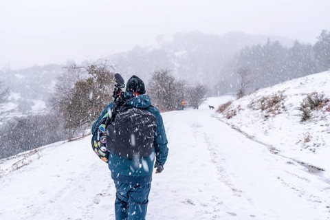 A young photographer walking in the aizkorri mountain of gipuzkoa. Snowy landscape by winter snows.
