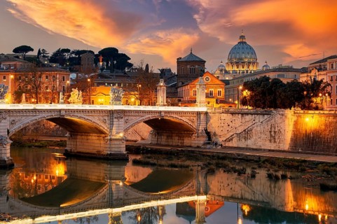 View of the Tiber River and Saint Peter's Basilica at sunset in Rome Italy