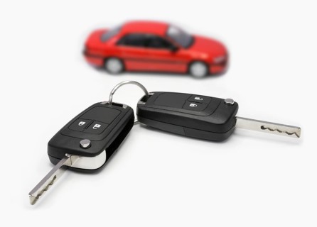 Ignition keys with car in the background