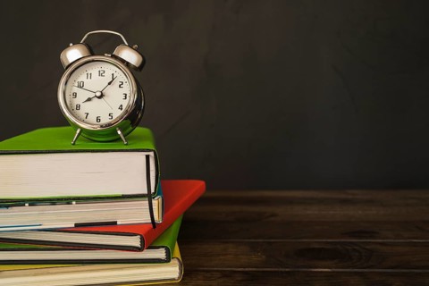 Alarm clock with books pile desk