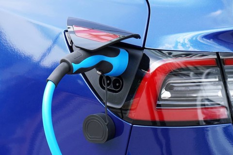 EV or Electric car at charging station with plug-in power supply cable - e-mobility concept