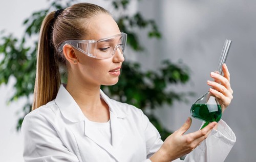 Side view female researcher with test tube safety glasses