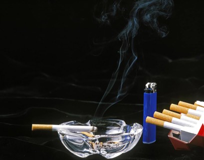 Cigarettes with Ashtray and Lighter against Black Background
