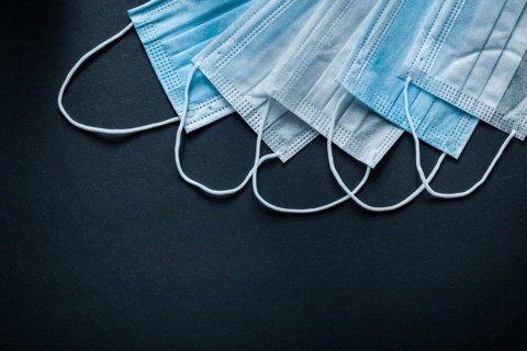 Disposable protective sterile masks on black background