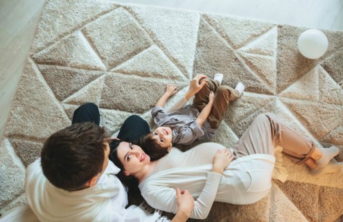 View from above of happy family with small kid expecting new baby. Pregnant mother, father and