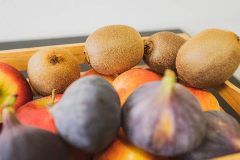 Apples, kiwi and fig in a wooden fruit basket as a healthy meal, Hanover, Lower Saxony, Germany,