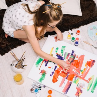 Girl painting with bright gouache paper floor