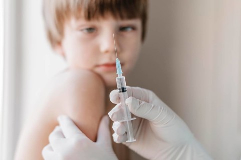 Doctor with gloves getting vaccine kid