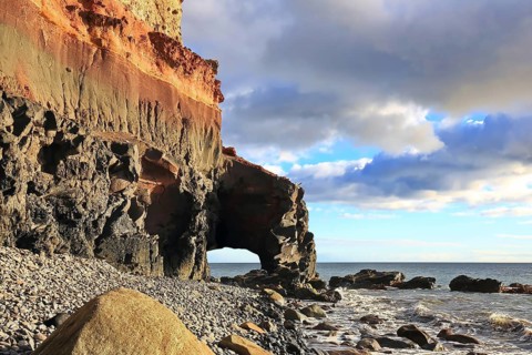 Lonely beach with a natural stone arch on the Atlantic Ocean in the Canary Islands. Playa de