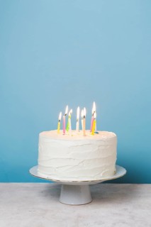 Front view lit candles birthday cake. High resolution photo