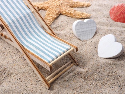 Blue deckchair with starfish in the sand on a beach