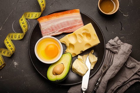 Keto foods as butter, olive oil, fried egg, avocado, fat meat bacon, cheese for ketogenic diet on