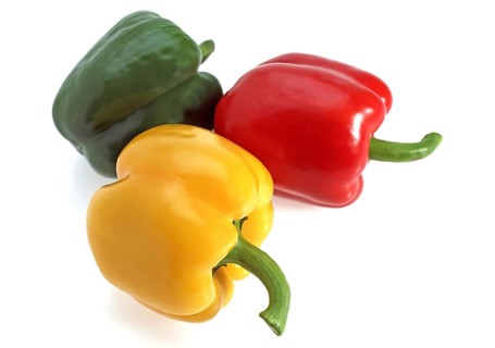 Red yellow and green peppers (capsicum) annuum, against white background