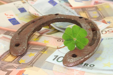 Rusty horseshoe with lucky clover and lots of euro notes