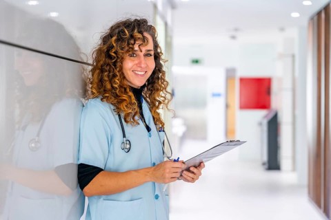 Happy nurse looking at camera and smiling while working in the hospital