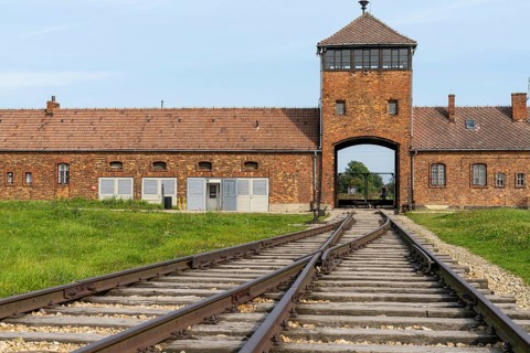 Auschwitz, Poland - 15 September, 2021: view of the gatehouse and train tracks at Auschwitz
