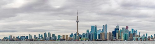 A panorama picture of the Toronto Skyline on a cloudy day taken from the islands across