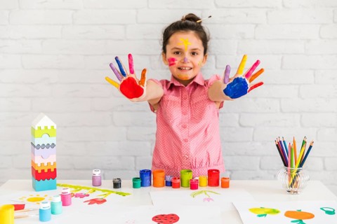 Smiling portrait girl showing her painted colorful hand camera