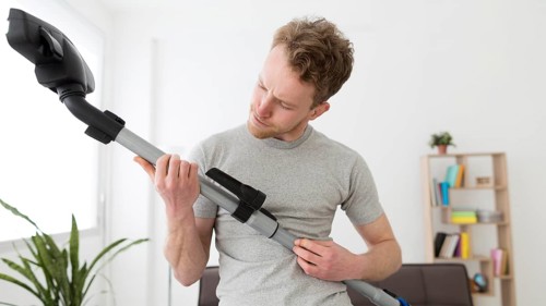 Man with vacuum cleaning house