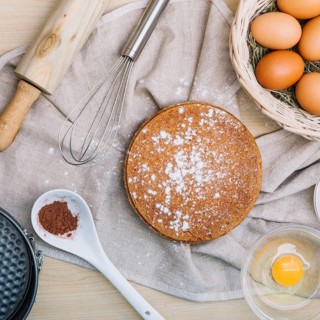 Sponge cake with icing sugar ingredients wooden table