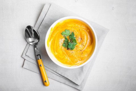 Pumpkin soup with parsley on grey napkin background