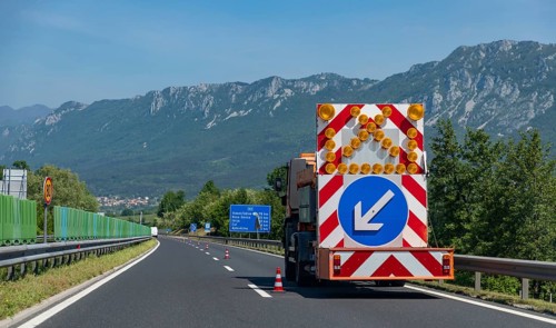 A picture of an arrow pointing to a construction area ahead on a Slovenian highway