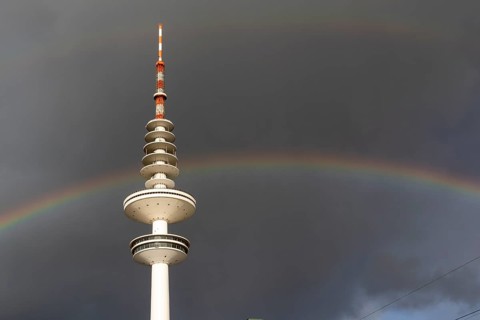 Weather symbol, Telemichel TV tower in front of a dramatic stormy sky with rainbow, Hamburg,