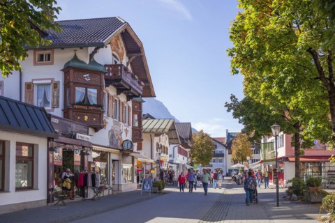 Houses, shops and people in the pedestrian zone of Garmisch in the evening light, district