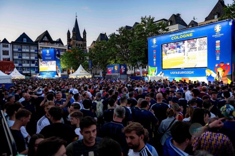 Lively scene where people gather in the evening in Cologne for public viewing of UEFA euro 2024.