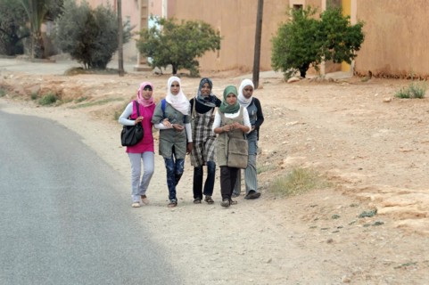 Group of girls walking together with school bags on a street, Middle Atlas, Rissani, Morocco,