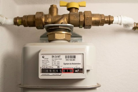 Symbolic image of energy costs in the household, natural gas, analogue gas meter in a flat,