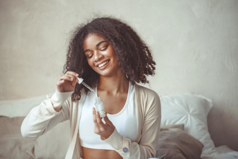 Beauty and skincare concept. Cropped photo of african american young female model holding bottle