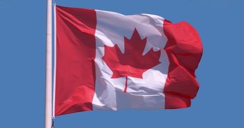 Canadian Flag Waving in the Wind against blue sky