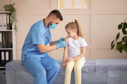 Young doctor vaccinating little girl