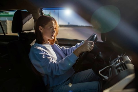 Young beautiful woman driver driving a car, happy trip, spring travel