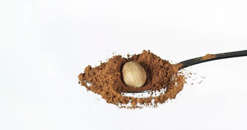 Nutmeg, myristica fragans, Powder falling against White Background