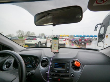 Inside view of a car with navigation on, stuck in traffic on a cloudy day, A1 A8 highway near