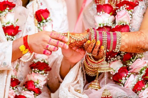 Indian groom passing bangles on his brides hand on her wedding ceremony, Mauritius, Africa