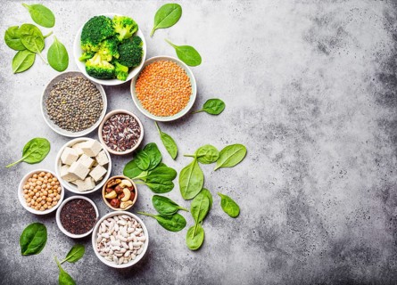 Top view of different vegan protein sources with space for text: beans, lentils, quinoa, tofu,