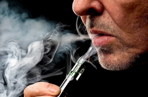 Close up portrait of a man smoking an e-cigarette
