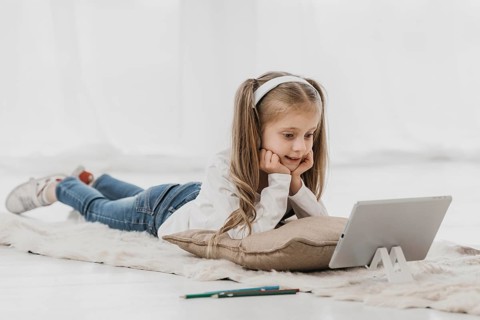 School girl wearing headphones attending online classes