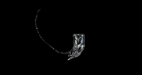 Glass of Water Bouncing and Splashing on Black Background