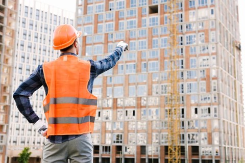 Back view man pointing building